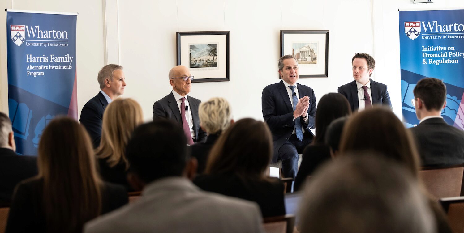 A panel speaks to an audience at a conference